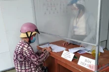 Một cụ già bán vé số nhận hỗ trợ tại phường Mỹ Xuyên, thành phố Long Xuyên.
