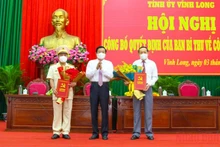 Bí thư Tỉnh ủy Vĩnh Long tặng hoa chúc mừng tân Phó Bí thư Tỉnh ủy Vĩnh Long Nguyễn Thành Thế (phải) và Đại tá Nguyễn Trọng Dũng, Giám đốc Công an tỉnh Vĩnh Long. (Ảnh: Bá Dũng)
