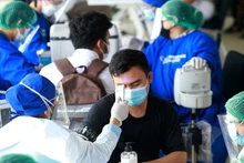 Kiểm tra thân nhiệt trước khi tiêm vaccine ngừa Covid-19 tại Jakarta, Indonesia. (Ảnh: Reuters)