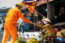 Công nhân ngành điện Miền nam phát tờ rơi hướng dẫn người dân sử dụng điện tiết kiệm, hiệu quả trong thời gian giãn cách.