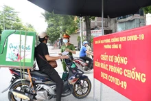 Lực lượng chức năng phường Cống Vị, quận Ba Đình kiểm tra giấy tờ tùy thân tại chốt kiểm soát dịch Covid-19 trên phố Đội Cấn. (Ảnh: THANH HẢI)