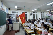 Lễ chào cờ đầu tuần diễn ra trong lớp học thay vì tập trung ở sân trường, của học sinh tiểu học. Ảnh: DUY LINH