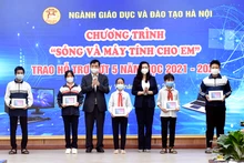 Các Phó giám đốc Sở: Phạm Xuân Tiến, Trần Lưu Hoa trao máy tính cho đại diện các em học sinh có hoàn cảnh khó khăn huyện Ba Vì.