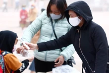 Mỗi học sinh Trường Phổ thông Dân tộc bán trú Trần Văn Thọ đều cô giáo đo thân nhiệt, hướng dẫn sát khuẩn tay trước khi vào trường.
