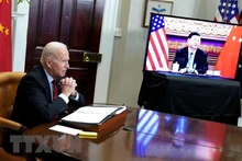 Tổng thống Mỹ Joe Biden (trái) và Chủ tịch Trung Quốc Tập Cận Bình (trên màn hình) trong cuộc hội đàm thượng đỉnh trực tuyến, tại Washington DC., ngày 15/11/2021. (Ảnh: AFP/TTXVN)