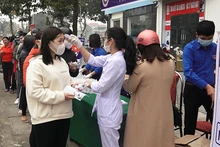 Nhân viên y tế kiểm tra thân nhiệt, cấp phát vật tư phòng dịch cho nhân dân ở huyện Hoằng Hóa.