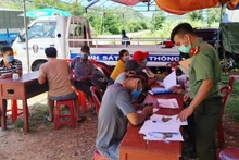 Lực lượng công an hướng dẫn người dân khai báo y tế ở chốt kiểm dịch xã Canh Hòa, huyện Vân Canh, tỉnh Bình Định.