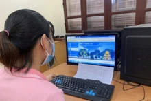 Túc trực hỗ trợ cha mẹ học sinh đăng ký thử nghiệm tuyển sinh trực tuyến tại Trường tiểu học Ba Trại B, huyện Ba Vì. 