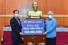 Bộ trưởng Ngoại giao Bùi Thanh Sơn trao tượng trưng số tiền 500 triệu đồng tới Bí thư Trung ương Đảng, Chủ tịch Ủy ban Trung ương Mặt trận Tổ quốc Việt Nam Đỗ Văn Chiến. (Ảnh: MOFA)