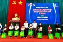 Ông Nguyễn Trân Châu, Phó Giám đốc Thường trực Quỹ “Học bổng Vừ A Dính”, Phó Tổng Biên tập Báo Thiếu niên Tiền phong và Nhi đồng trao học bỗng cho các em học sinh.