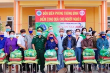Đại diện đoàn thiện nguyện, địa phương và Đồn Biên phòng Thông Bình trao quà cho hộ nghèo. (Ảnh: Phú Quý)