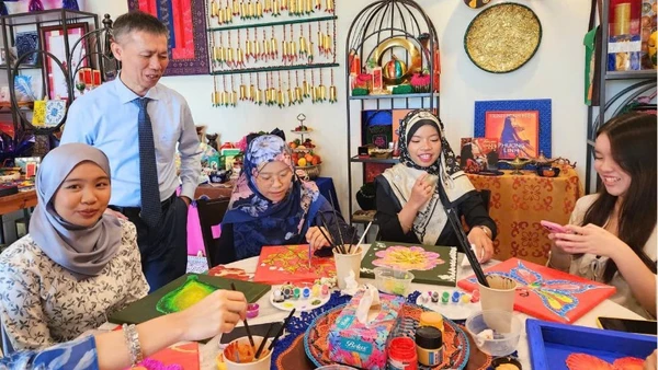 Tiến sĩ Trần Trọng Nghĩa và sinh viên Đại học Quốc gia Brunei trải nghiệm hoạt động trang trí họa tiết truyền thống của Việt Nam và Brunei Darussalam. (Ảnh do Đại sứ quán Việt Nam tại Brunei cung cấp)