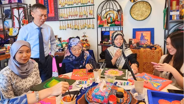 Tiến sĩ Trần Trọng Nghĩa và sinh viên Đại học Quốc gia Brunei trải nghiệm hoạt động trang trí họa tiết truyền thống của Việt Nam và Brunei Darussalam. (Ảnh do Đại sứ quán Việt Nam tại Brunei cung cấp)