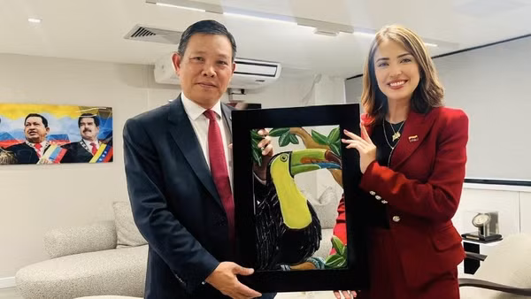 Bộ trưởng Du lịch Venezuela Daniella Cabello trao quà kỷ niệm tặng Đại sứ Vũ Trung Mỹ. (Ảnh do Đại sứ quán Việt Nam tại Venezuela cung cấp)