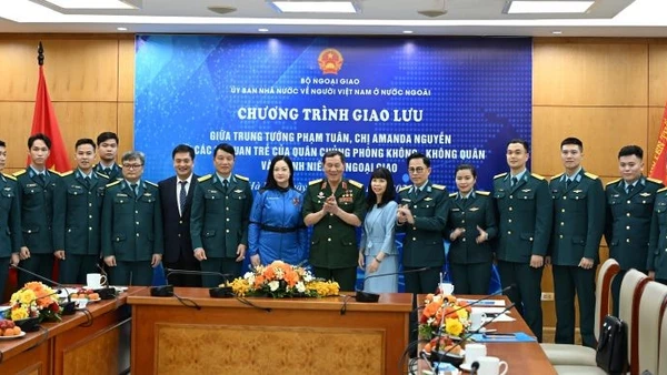 Trung tướng Phạm Tuân và nữ phi hành gia Amanda Nguyễn chụp ảnh kỷ niệm với các đại biểu tham gia giao lưu. (Ảnh: Ủy ban Nhà nước về người Việt Nam ở nước ngoài cung cấp)