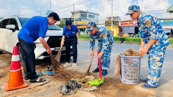 Cán bộ, chiến sĩ Vùng 5 Hải quân và đoàn viên thanh niên địa phương vệ sinh đường giao thông. 