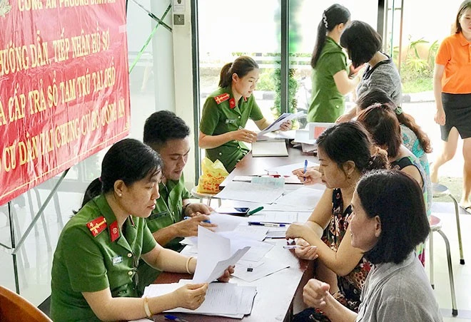 Công an Thành phố Hồ Chí Minh hướng dẫn người dân làm thủ tục đăng ký cư trú. (Ảnh: NHÂN SƠN)