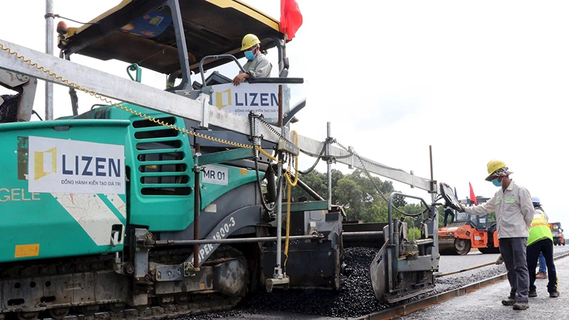 Nhà thầu tiến hành thảm nhựa lớp đầu tiên tại gói thầu số 21, thuộc dự án thành phần 1, đường cao tốc Biên Hòa-Vũng Tàu, đoạn qua tỉnh Đồng Nai. (Ảnh Công Phong)