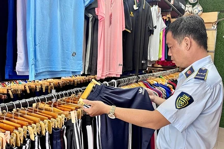 Lực lượng quản lý thị trường thành phố kiểm tra một điểm kinh doanh sản phẩm thời trang vi phạm. (Ảnh CTV).