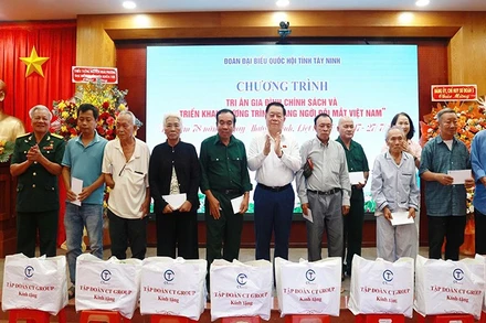 Đồng chí Nguyễn Trọng Nghĩa trao quà và hoa tri ân các gia đình chính sách.