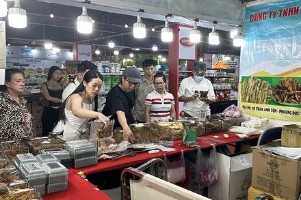 Khách du lịch nước ngoài tham quan và mua sắm hải sản khô tại một gian hàng trong chiều ngày 17/11.