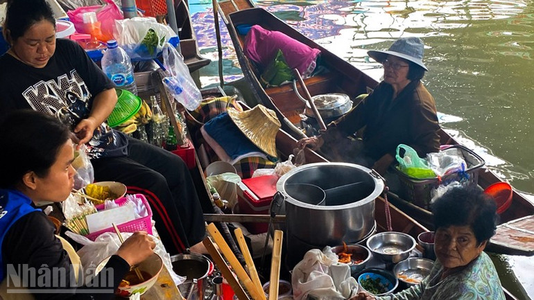 Du khách thưởng thức những món ăn truyền thống của Thái Lan ngay trên thuyền. (Ảnh: XUÂN SƠN) ndo_bl_anh-3.jpg