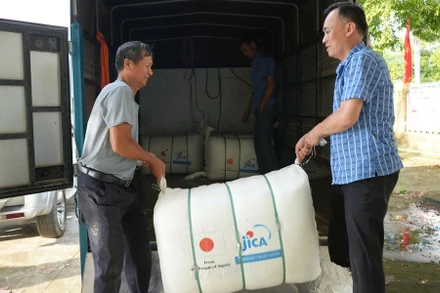 Lãnh đạo xã Hợp Thịnh hỗ trợ vận chuyển quà tặng về cho bà con các thôn. (Ảnh: MAI TOAN)