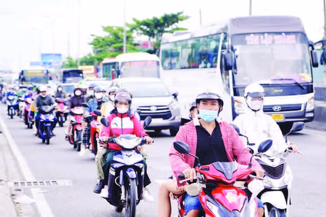Xe máy lưu thông trên Quốc lộ 1, đoạn qua cầu Bình Điền. (Ảnh THẾ ANH)