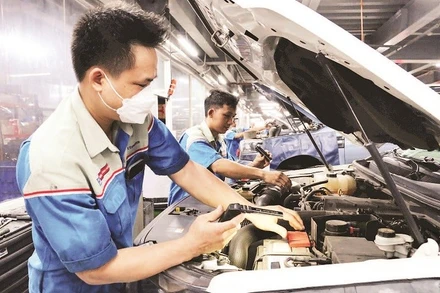 Công nhân Công ty Bến Thành Ford đang chăm sóc xe cho khách hàng. (Ảnh THẾ ANH)