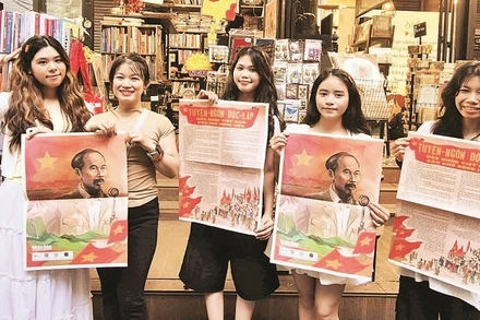 Nhiều bạn trẻ vui mừng khi nhận được phụ san đặc biệt của Báo Nhân Dân tại Đường Sách Thành phố Hồ Chí Minh. (Ảnh THANH THÚY)