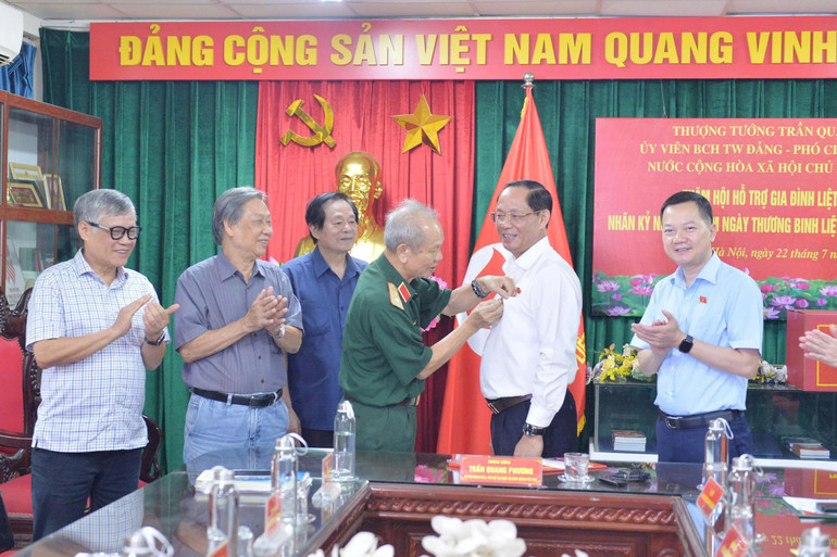 Trung tướng Hoàng Khánh Hưng, Chủ tịch Hội Hỗ trợ gia đình liệt sĩ Việt Nam trao huy hiệu của Hội cho Thượng tướng Trần Quang Phương. anh-5.jpg