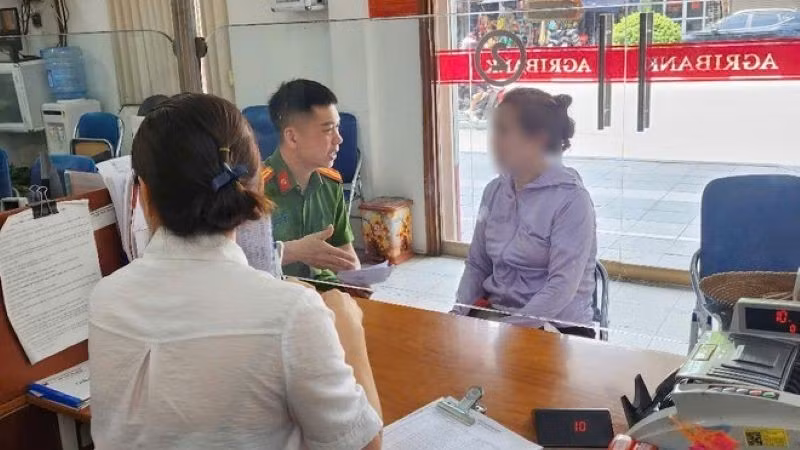 Cán bộ công an và nhân viên ngân hàng giải thích cho bà T. về thủ đoạn của các đối tượng lừa đảo. Ảnh: ANTĐ