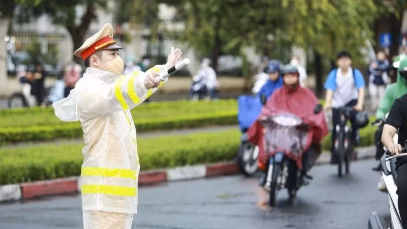 Cảnh sát giao thông điều tiết phòng ngừa ùn tắc trong mưa.