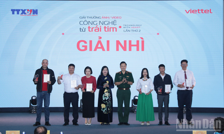 លោកស្រី Tran Thi Thu Dong អនុប្រធានសមាគមន៍អក្សរសិល្ប៍ និងសិល្បៈវៀតណាម ប្រធានសមាគមសិល្បករថតរូបវៀតណាម និងឧត្តមសេនីយ៍ឯក Nguyen Van Duc ប្រធាននាយកដ្ឋានឃោសនា ក្រសួងការពារជាតិ ប្រគល់រង្វាន់លើកទី២ ដល់អ្នកនិពន្ធ។ (រូបថត៖ THANH GIANG) ndo_br_ba4a6126.jpg