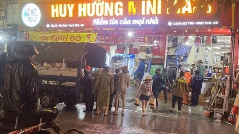 Lực lượng chức năng hỗ trợ người dân di dời ra khỏi khu vực sạt lở nguy hiểm. 