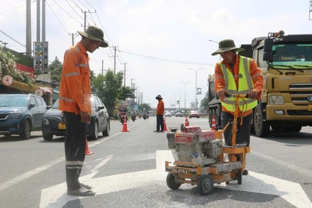 Công nhân sơn kẻ vạch đường trên Quốc lộ 51. 