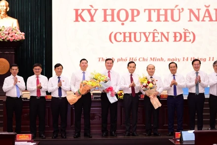 Bí thư Thành ủy Thành phố Hồ Chí Minh Trần Lưu Quang và lãnh đạo thành phố tặng hoa chúc mừng ba tân Phó Chủ tịch Ủy ban nhân dân thành phố. (Ảnh: QUANG ĐỊNH)