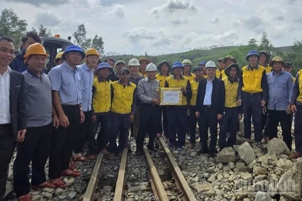 Thứ trưởng Xây dựng Nguyễn Danh Huy (mũ trắng, áo xám, đứng giữa) thị sát chỉ đạo công trường khắc phục sự cố đường sắt và tặng quà công nhân thi công.