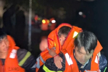 Lực lượng cứu hộ đưa người dân và trẻ em ra khỏi vùng ngập lụt. 