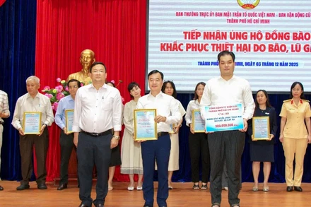 Đồng chí Trần Vũ Quang (đứng giữa), Ủy viên Ban Thường vụ, Chủ nhiệm Ủy ban Kiểm tra Đảng ủy EVNHCMC thay mặt tập thể cán bộ, công nhân viên Tổng công ty trao số tiền 300 triệu đồng đến Ủy ban Mặt trận Tổ quốc Việt Nam Thành phố Hồ Chí Minh.