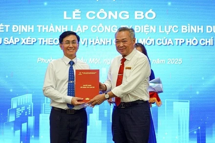 Bí thư Đảng ủy EVNHCMC Phạm Quốc Bảo (phải) trao quyết định thành lập công ty Điện lực Bình dương (trực thuộc EVNHCMC) tại buổi lễ.