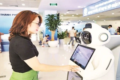 Người dân sử dụng robot AI hỗ trợ, tư vấn thủ tục hành chính tại Trung tâm Phục vụ hành chính công thành phố Hà Nội. (Ảnh LÊ HẢI)