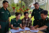 Cán bộ Bộ đội Biên phòng Sơn La hỗ trợ em Thào Tra Pó làm hồ sơ nhập học vào trường Đại học Tài nguyên và Môi trường.