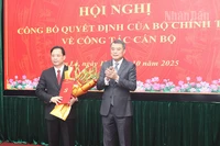 Đồng chí Lê Minh Hưng, Ủy viên Bộ Chính trị, Bí thư Trung ương Đảng, Trưởng ban Tổ chức Trung ương trao quyết định của Bộ Chính trị và tặng hoa chúc mừng đồng chí Hoàng Văn Nghiệm.