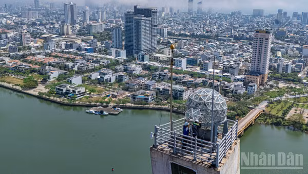 Các kỹ sư, kỹ thuật viên của Công ty cổ phần Cầu đường Đà Nẵng kiểm tra định kỳ hệ thống chiếu sáng trên đỉnh tháp trụ cầu Trần Thị Lý.