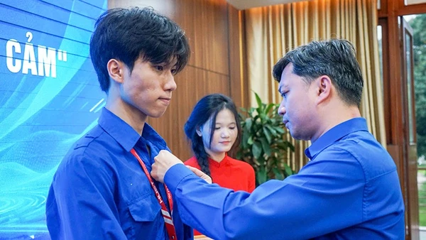 Bí thư Thường trực Trung ương Đoàn Nguyễn Minh Triết trao huy hiệu "Tuổi trẻ dũng cảm" tặng sinh viên Nguyễn Lê Tú.