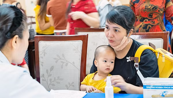 Các y, bác sĩ tình nguyện của "Hành trình yêu thương" thăm khám bà mẹ và trẻ em.