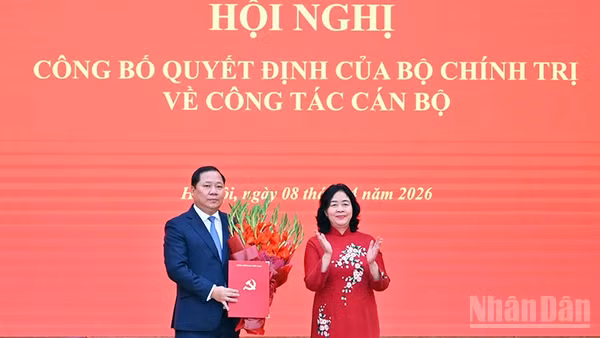 Đồng chí Bùi Thị Minh Hoài (bên phải) trao Quyết định của Bộ Chính trị, tặng hoa chúc mừng đồng chí Nguyễn Phi Long.