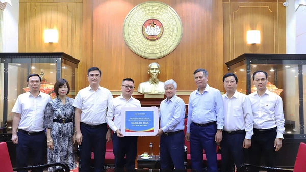 Đồng chí Đỗ Văn Chiến (thứ 4 từ phải sang) tiếp nhận số tiền ủng hộ từ tập thể lãnh đạo, cán bộ, người lao động Báo Nhân Dân.