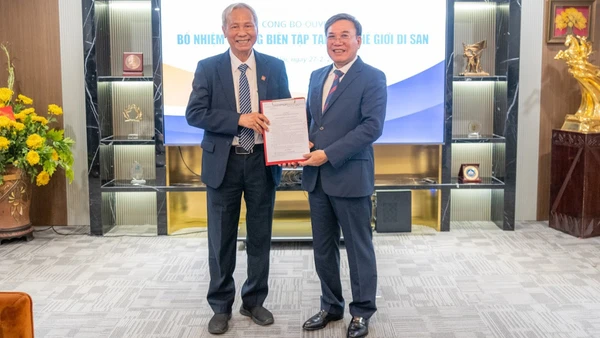 Phó Giáo sư, Tiến sĩ Đỗ Văn Trụ, Chủ tịch Hội Di sản Văn hóa Việt Nam (trái) trao quyết định cho Thạc sĩ, nhà báo Trịnh Thanh Giảng. 